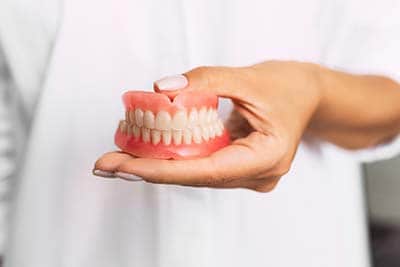 snap on dentures woman holding snap on dentures