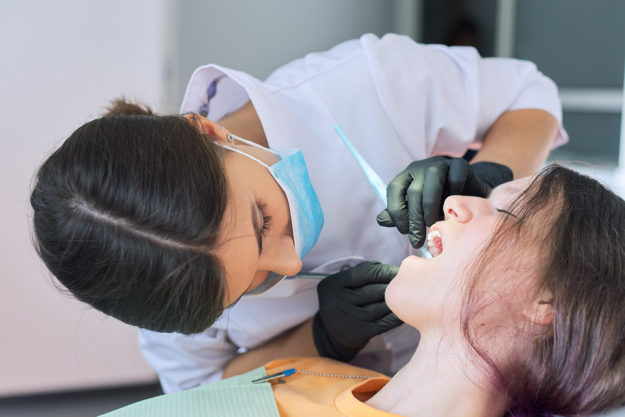 Close up dental treatment procedure in dental office dentist treating a chipped tooth in child patient
