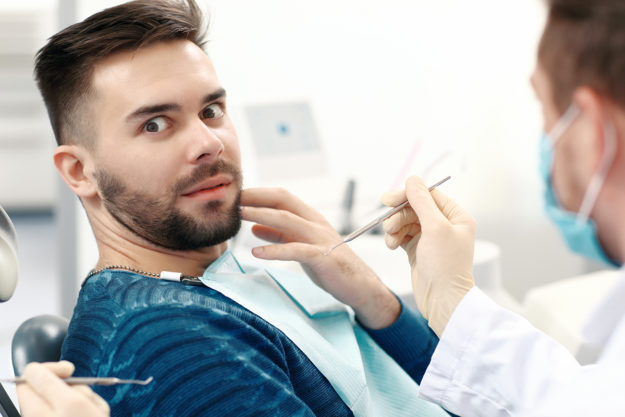 a man struggling with dentophobia at the dentist