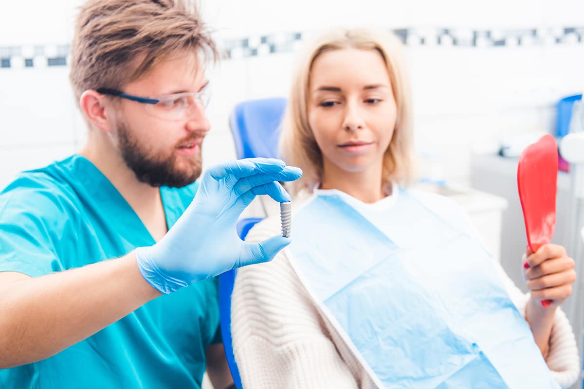 a. dental implant specialist talking to a patient